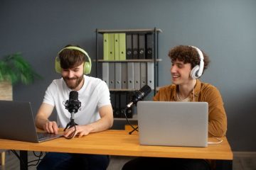 Imagem de um estúdio de web rádio moderno com mesa de som, microfones, fones de ouvido, computador e paredes com isolamento acústico.